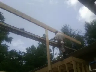 Carpenter setting a ridge beam over a new addition frame — Ice Dam Removal by Roofing Brothers in Dawson Springs