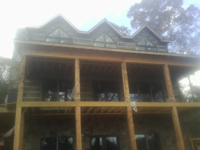 Dormers and porch framing on a large log home under construction — Roof Coating work by our crew in Dawson Springs