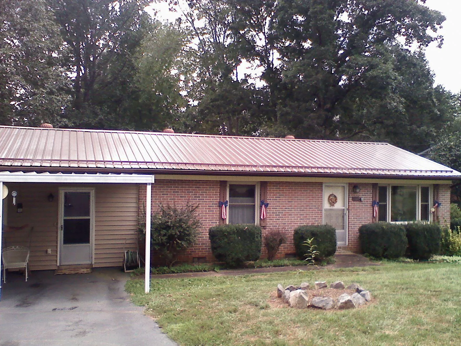 Bronze metal roof and carport on a brick ranch home — Roof Repair work by our crew in Dawson Springs