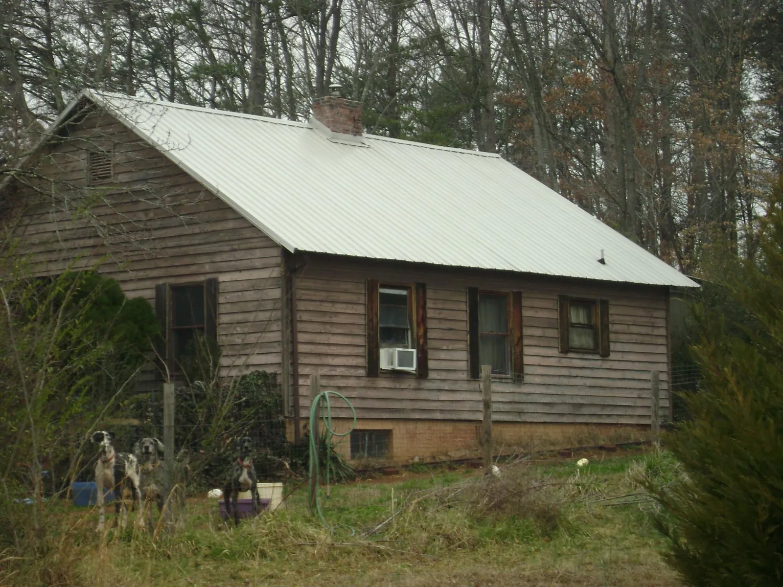 White metal roof on an old wood sided farmhouse, from a Metal Roof Installation job in Dawson Springs